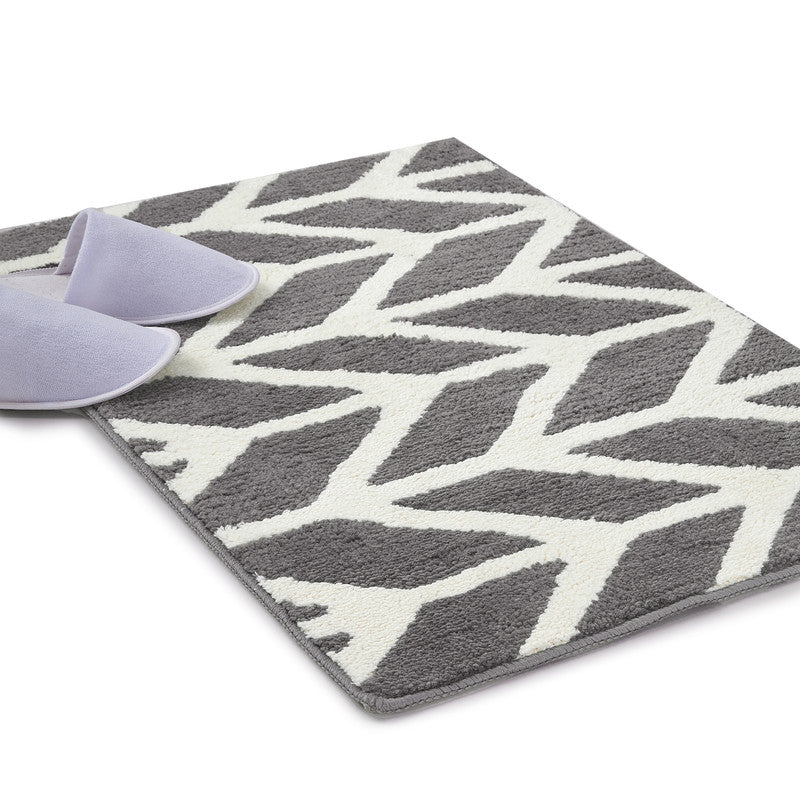 Grey microfibre quick-dry bathmat laid on a bathroom floor beside a shower