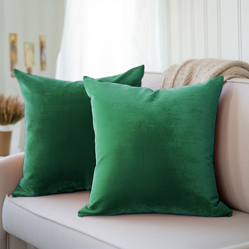 Green velvet cushion covers with a plush, even pile on a sofa
