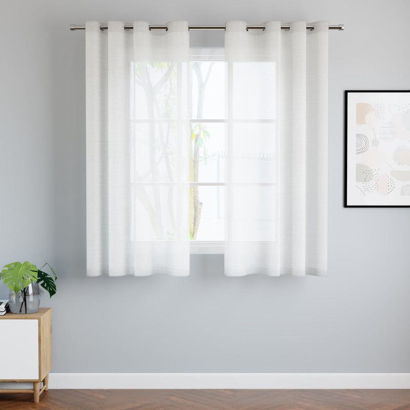 White cotton sheer curtains hung over a bright living-room window