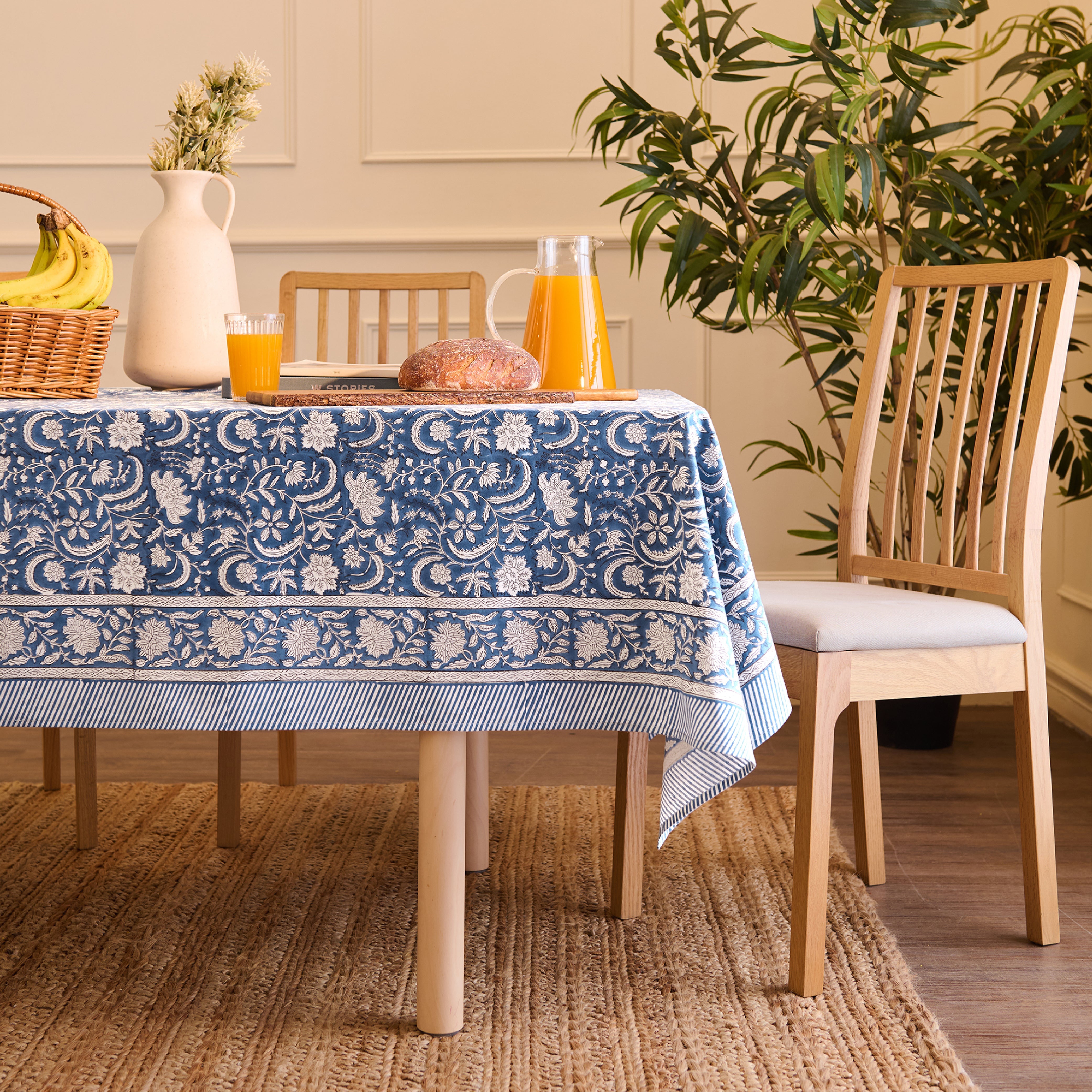 Blue hand block print cotton table cover laid on a wooden dining table
