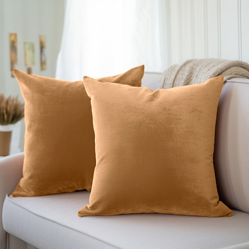 Gold velvet cushion covers arranged on a sofa, showing a full, well-filled shape
