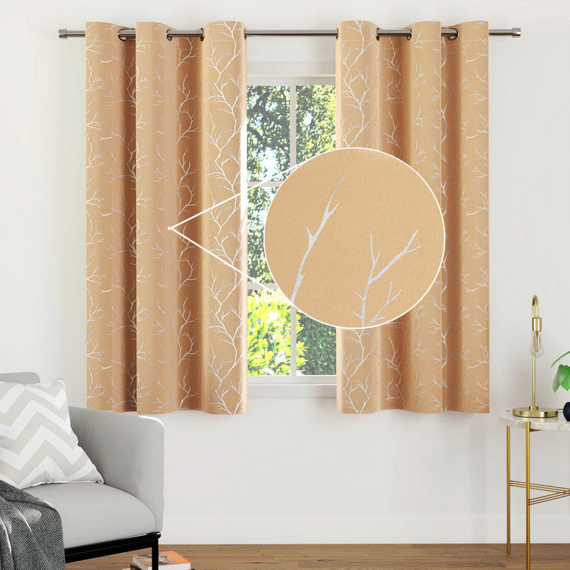 Blackout polyester curtain panel with a beige twig print hanging across a window