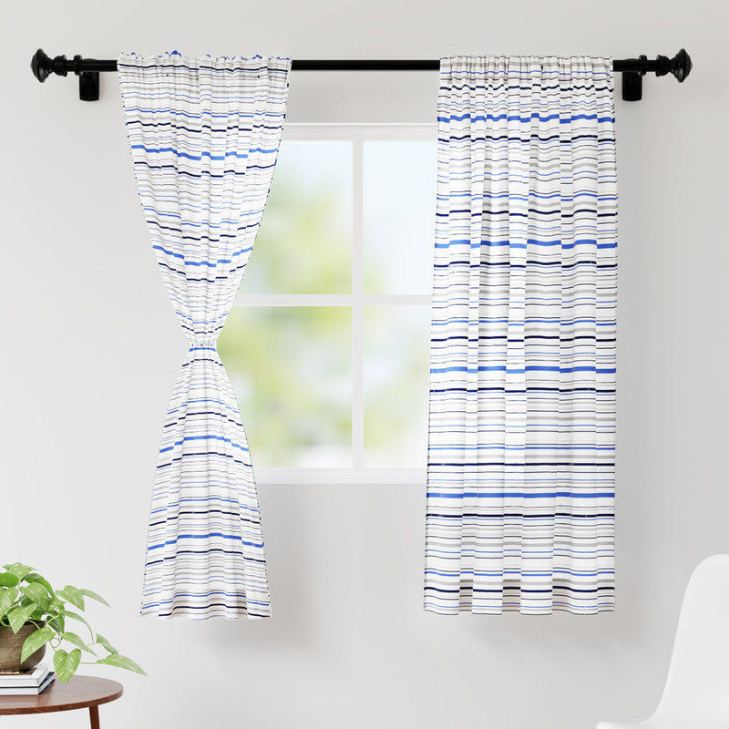 Blue and grey striped curtain pair on a black rod, the left panel gathered at its tie-back over a small window