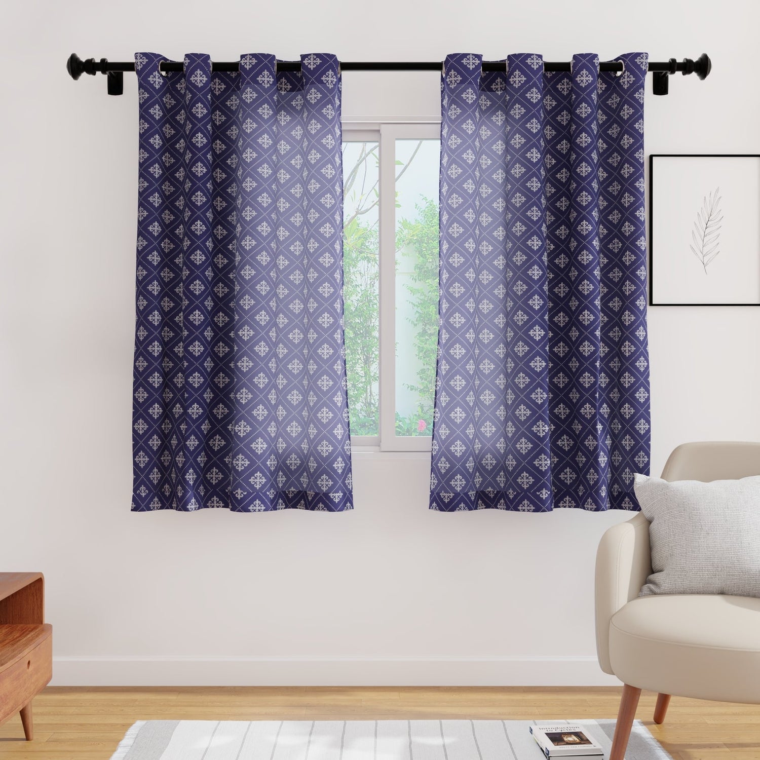 Navy Moroccan-print curtains framing a window in a styled living room with armchair