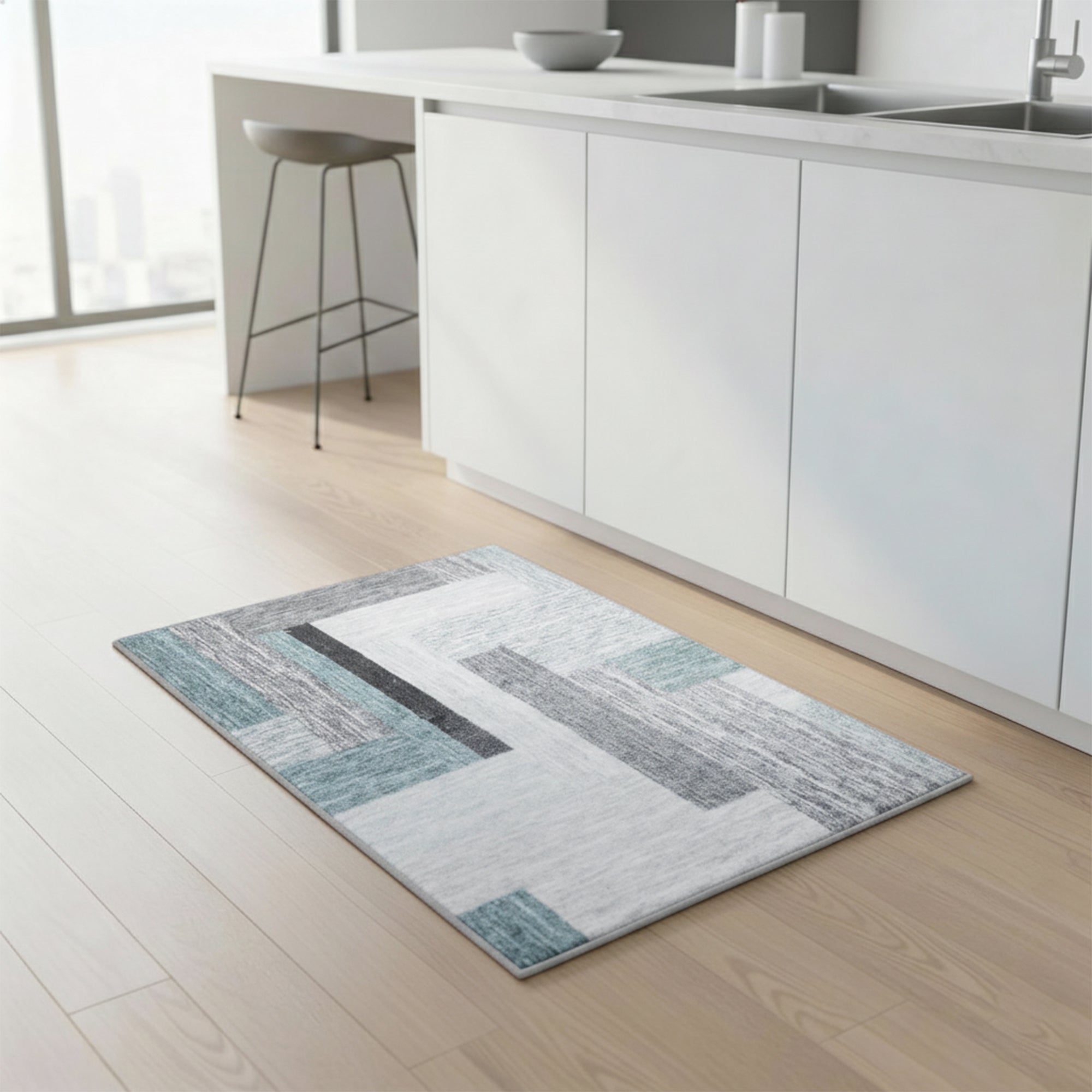 Grey and teal patterned polyester bath mat laid on a pale wood floor